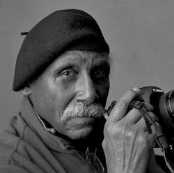 Black and white photo of Adger Cowans holding a camera 