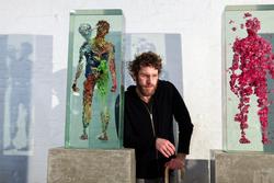Dustin Yellin at his studio in Red Hook, Brooklyn, flanked by two of his see-through sculptures. Credit: Danny Ghitis for The New York Times