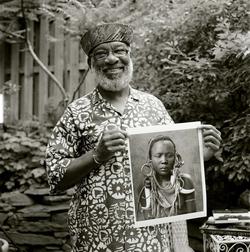 Black and white photo of photographer Chester Higgins holding photograph