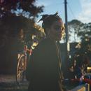 Poet Imani Elizabeth Jackson sitting on a ledge outside partly lit