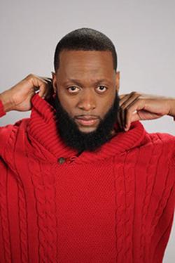 A photograph of Jive Poetic, wearing a read sweater.