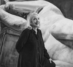 Photo of Joan Semmel in front of her work.