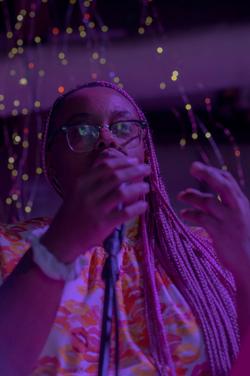 A photo with purple light of poet Naima Lowe A photo with purple light of poet Naima Lowe