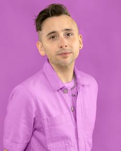 A photo of [Lorenzo Triburgo] in a pink shirt in front of a pink background