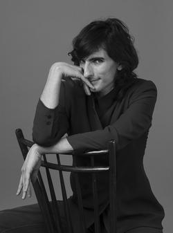 Black and white photo of Morgan Bassichis in a chair.