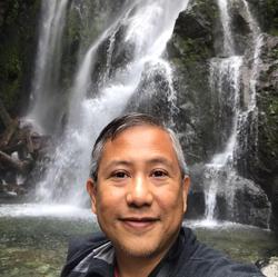 Photo of [Charles Valle] in front of a waterfall