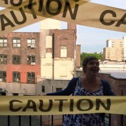Photo of Rebekah Smith behind caution tape. 