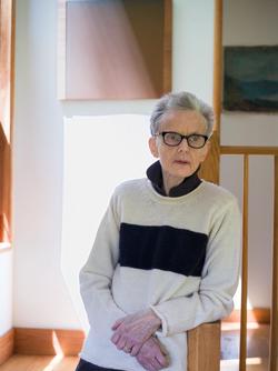 A photo of poet Susan Howe wearing glasses and looking to the side.